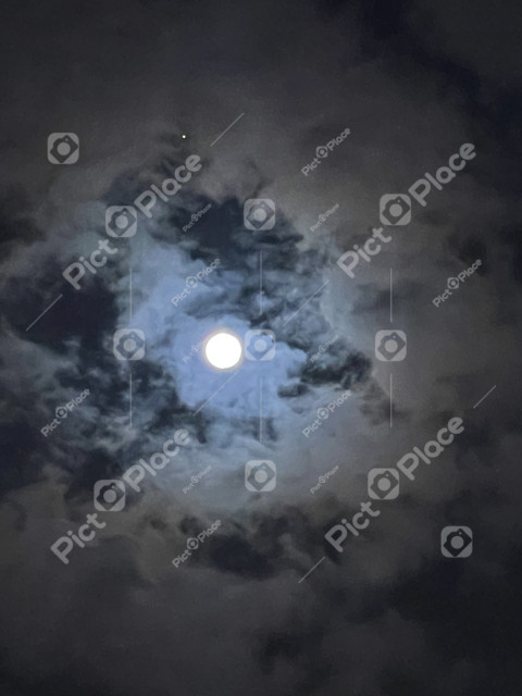 View of the full moon through the clouds