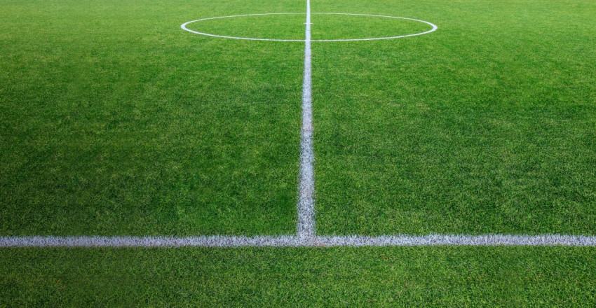 Green lawn football field with lines in perspective