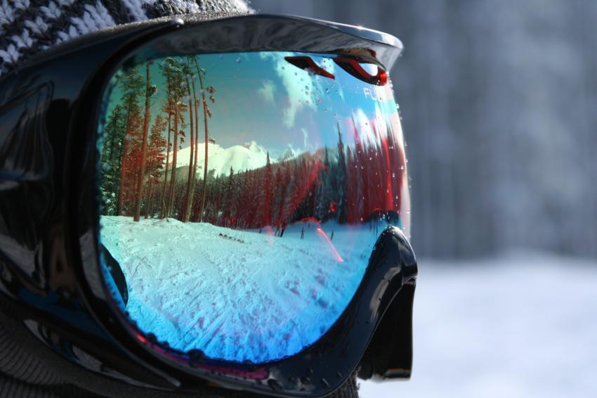 the reflection of a person in a pair of ski goggles