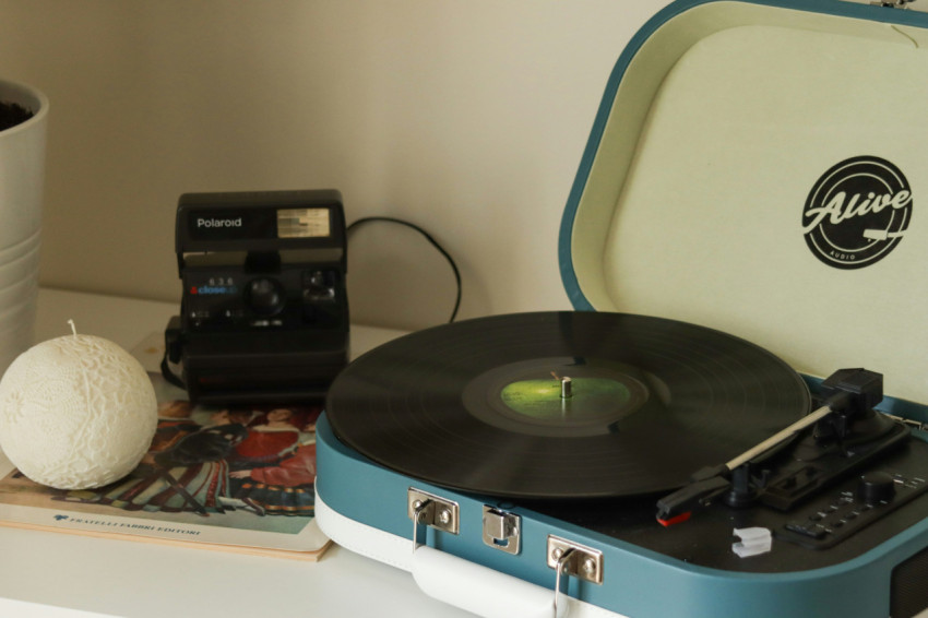 record player on a table next to a cup