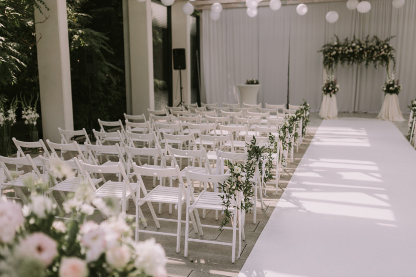 White chairs decorated for a wedding ceremony