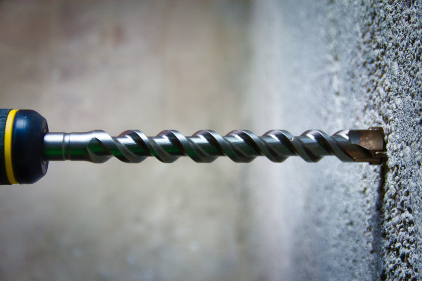 Drill on the background of concrete close-up