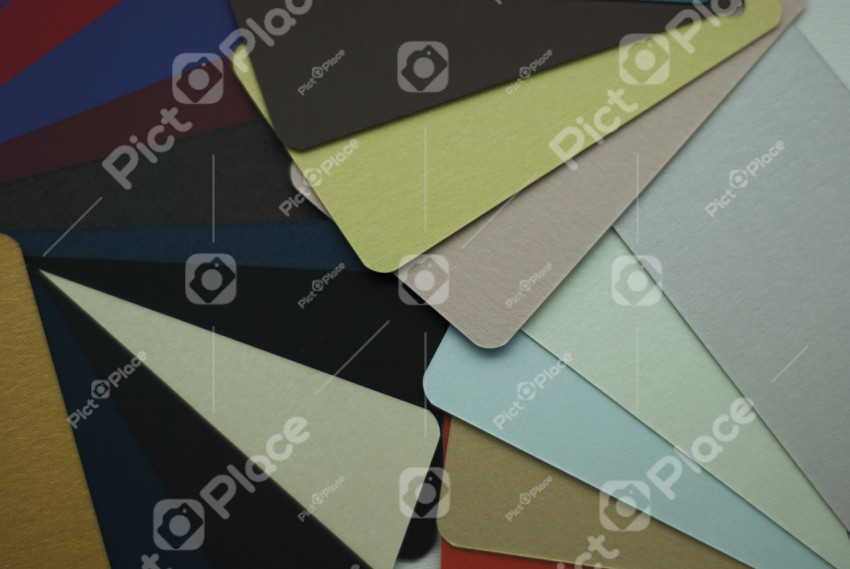 Colored cardboards on a black background. Close-up.
