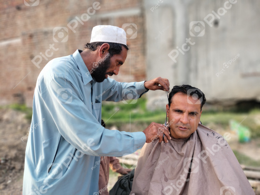 A picture of a barber cutting a man's hair