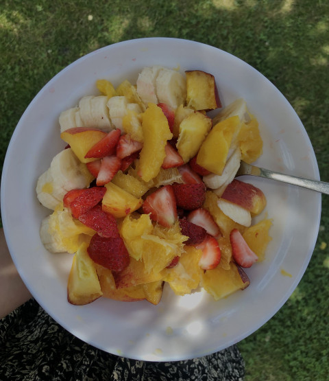 The most bright breakfast. Fruit salad plate close up top view