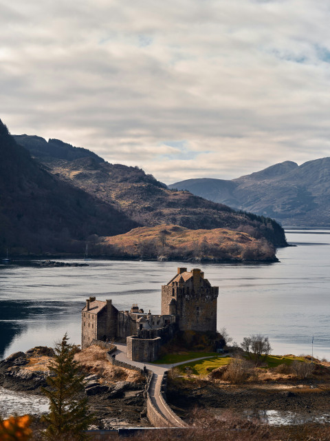 castle on a small island in the middle of a lake