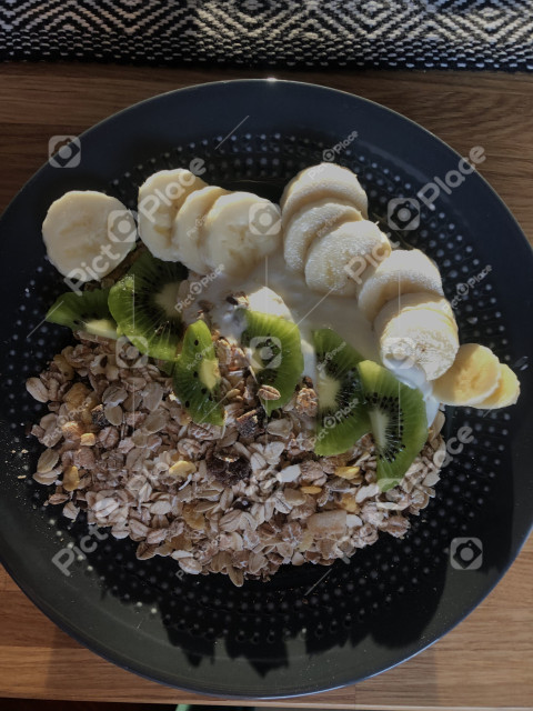 Health food. Plate of oatmeal with bananas and kiwi, top view