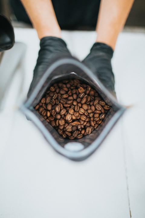 brown coffee beans in a gray ceramic bowl