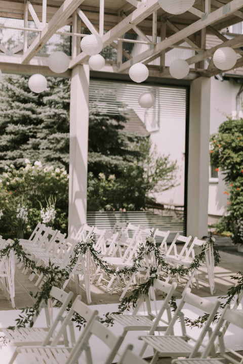 White chairs decorated for a wedding ceremony