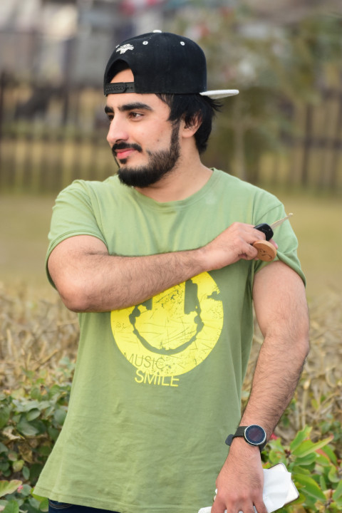 A smiling Pakistani man in a baseball cap